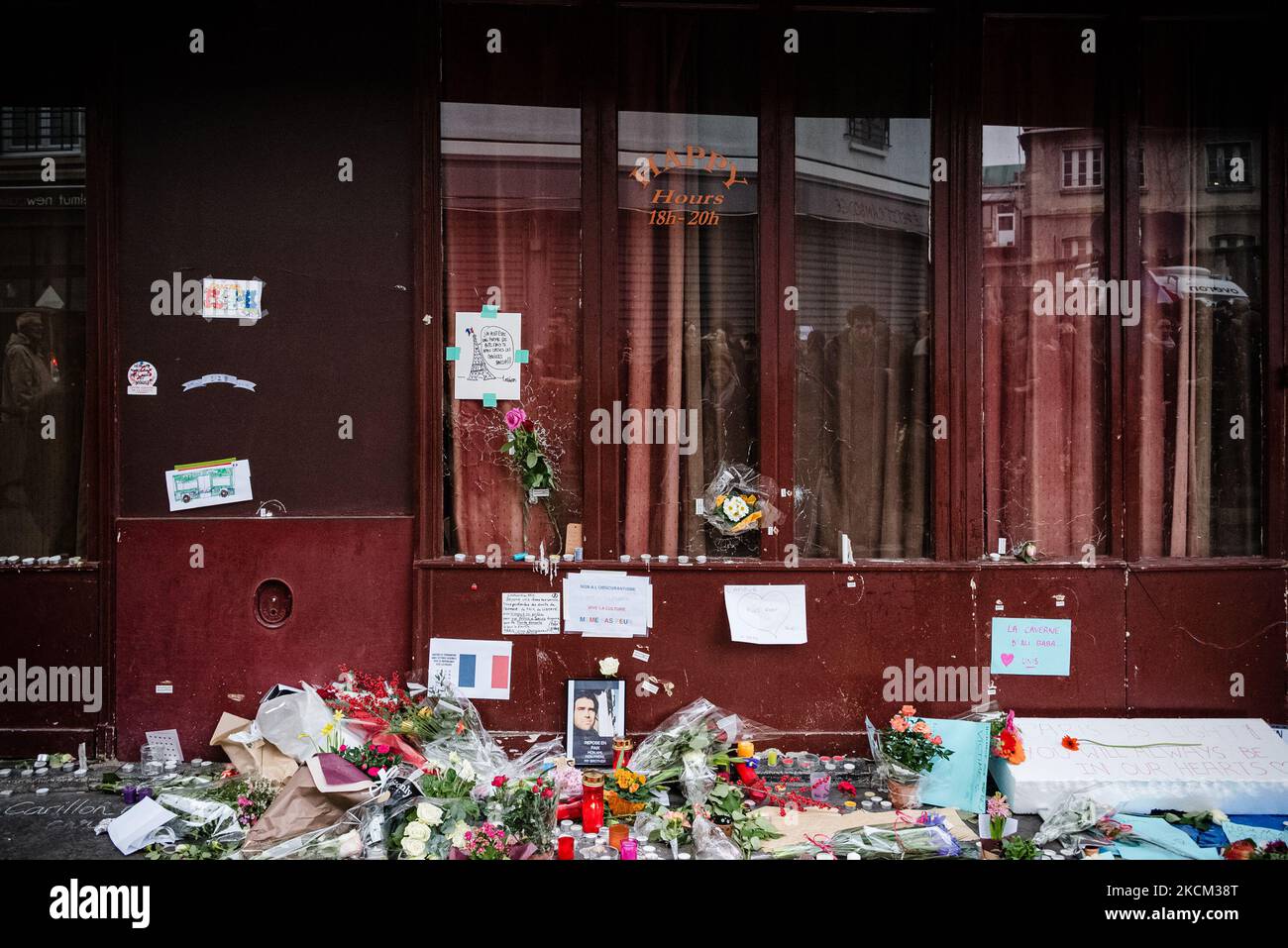 On November 16, 2015, three days after the attacks of November 13, 2015 that killed 130 people and injured more than 400 in a series of attacks that hit several places in Paris including the Stade de France, cafe terraces and the Bataclan concert hall the emotion is at its peak in the streets of Paris, as here in front of the terrace of the restaurant 'Le carillon' where passersby gather and lay flowers, candles and messages in tribute to the victims in front of one of the places of the attacks still marked by the impact of bullets. (Photo by Samuel Boivin/NurPhoto) Stock Photo