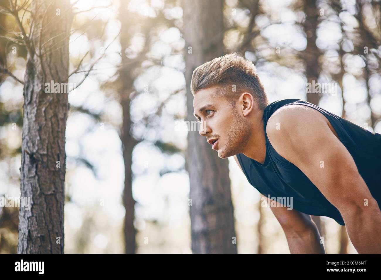 Check your breathing when you go for a run. a young man bending outdoors. Stock Photo