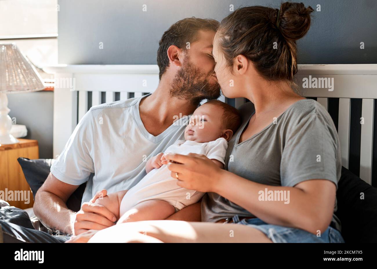 Hell be raised in a home of love. a young mother and father bonding with their newborn baby boy in the bedroom. Stock Photo