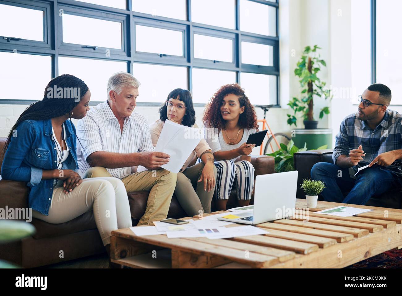 Advancing the vision to his young and upcoming team. a group of colleagues collaborating in a modern office. Stock Photo