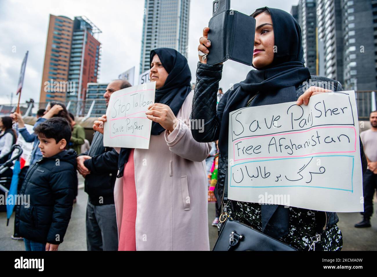 An Afghan family is holding placards in support of Afghanistan, during