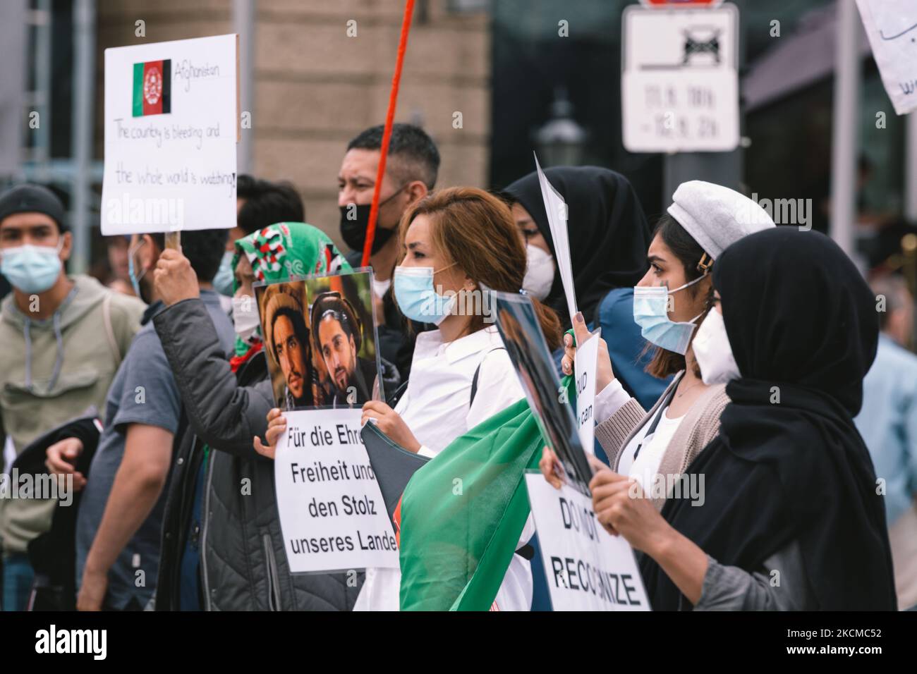 people hold the signs during the rally against newly all-male Taliban ...