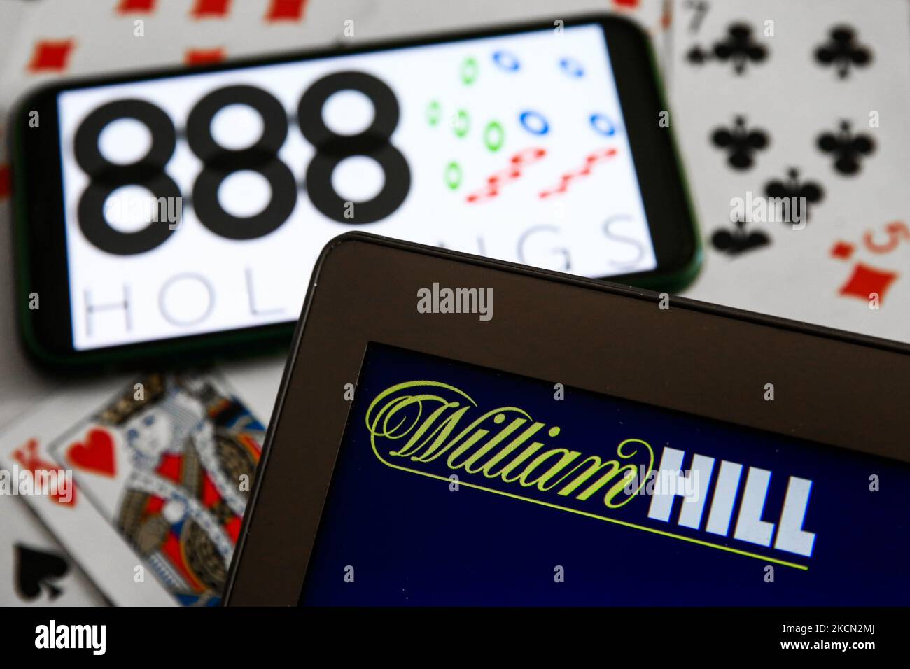 888 Holdings logo displayed on a mobile phone, William Hill logo displayed on a laptop screen and playing cards are seen in this illustration photo taken in Krakow, Poland on September 21, 2021. (Photo by Jakub Porzycki/NurPhoto) Stock Photo
