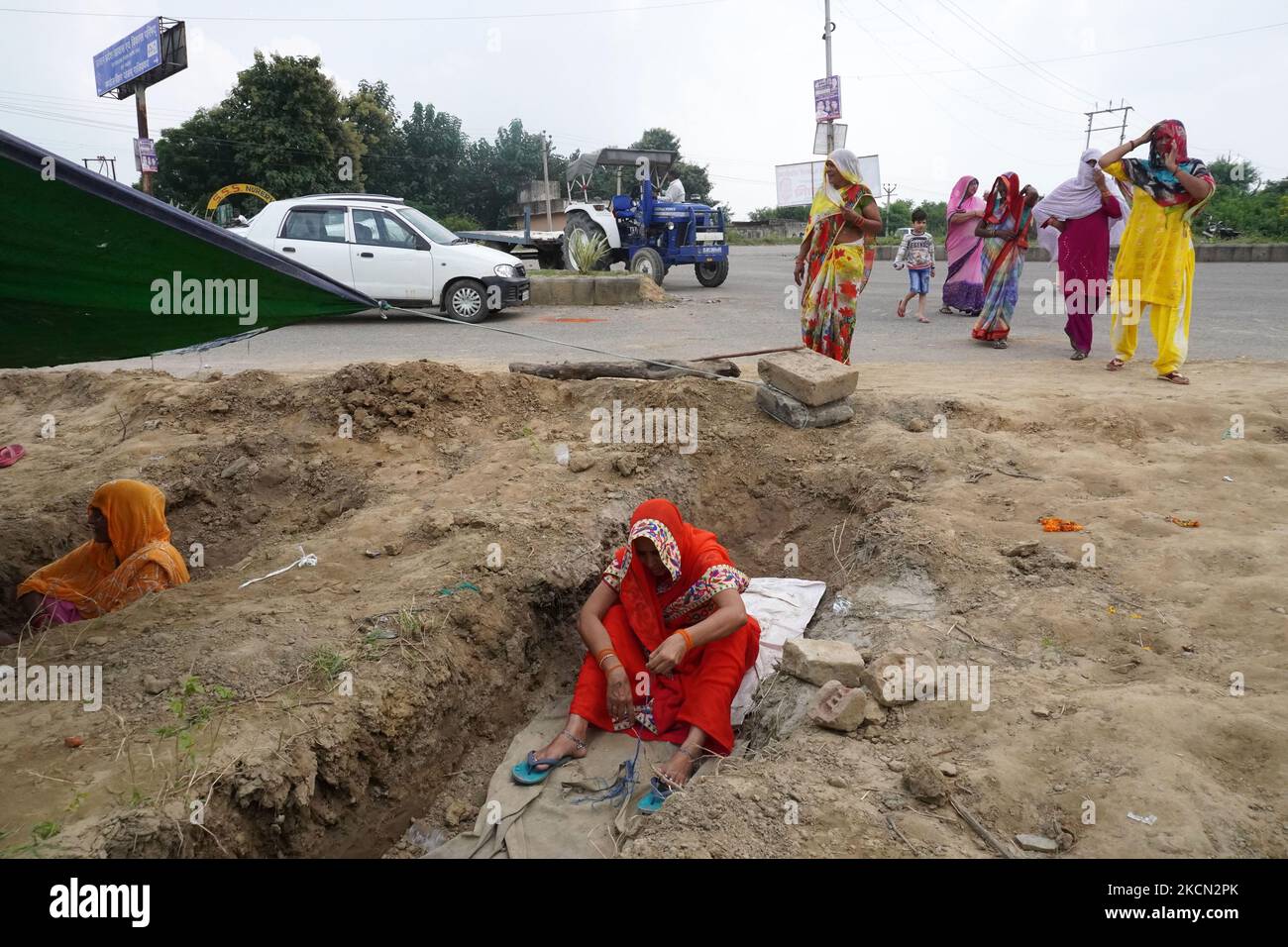 Women sit inside graves as farmers stage 'Zameen Samadhi' protest over three farm laws and an increase in land compensation, at Ghaziabad's Mandola village in the northern state of Uttar Pradesh, India on September 21, 2021. (Photo by Mayank Makhija/NurPhoto) Stock Photo