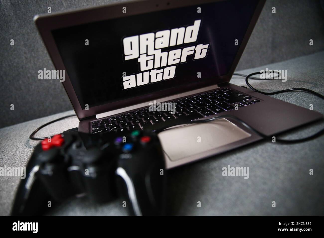 Grand Theft Auto logo displayed on a laptop screen and a gamepad are seen in this illustration photo taken in Krakow, Poland on September 21, 2021. (Photo by Jakub Porzycki/NurPhoto) Stock Photo