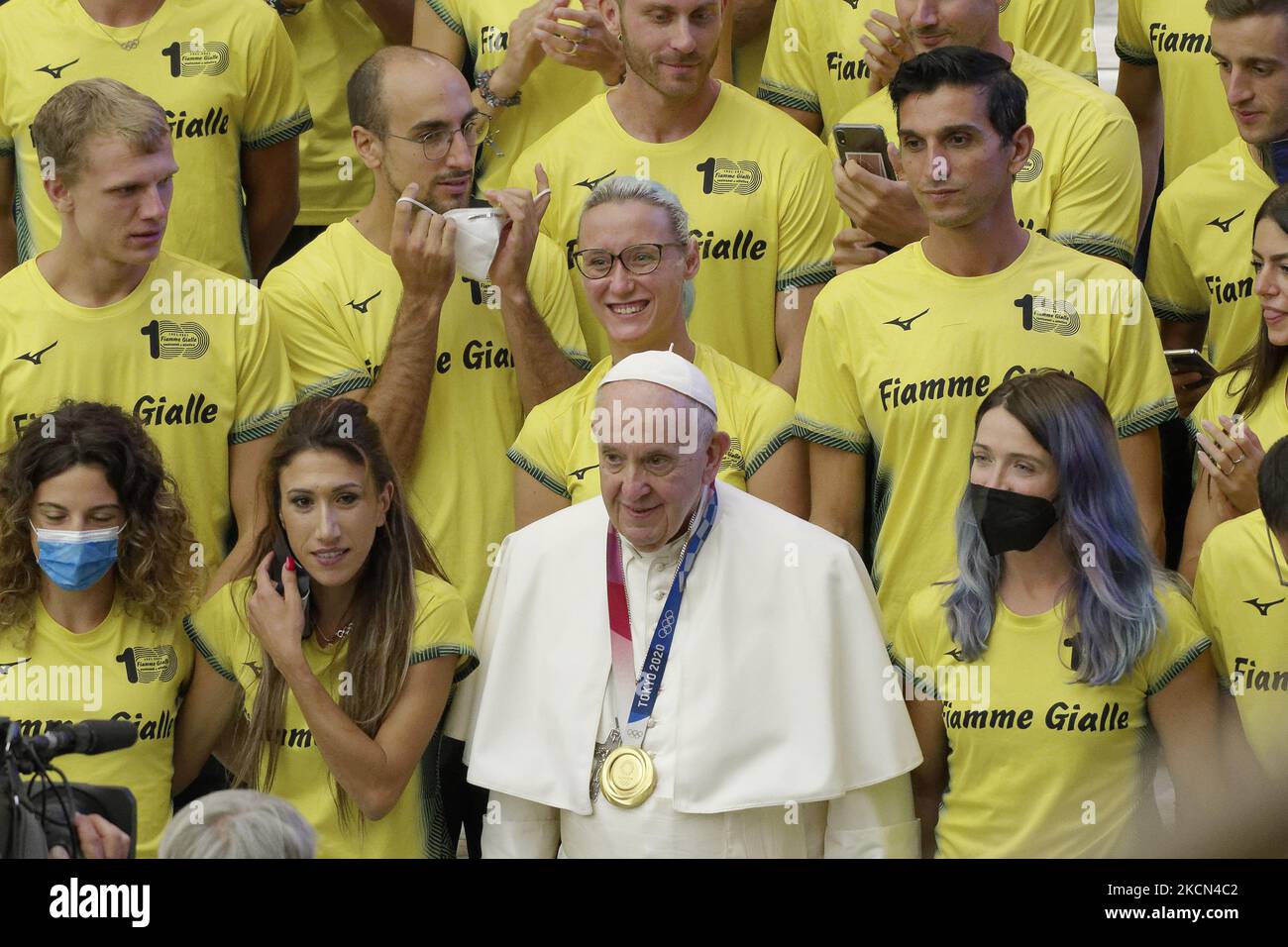 Pope Francis poses for a photo wearing an Olympic gold medal as he