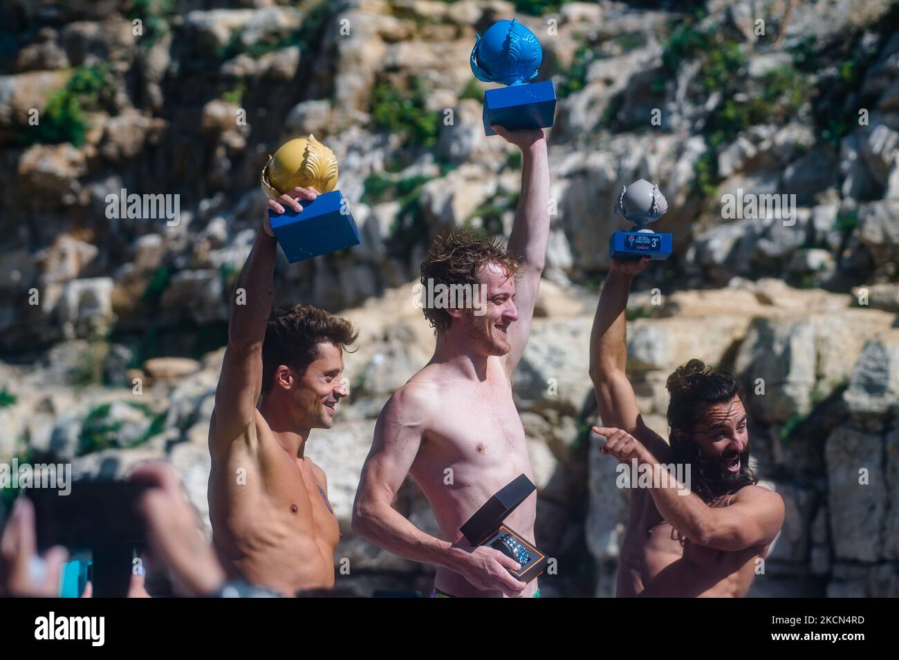 Divers on the podium in Polignano a Mare during the Red Bull Cliff Diving 2021 at Lama Monachile on 22 September 2021. Red Bull Cliff Diving has arrived in Puglia, in Polignano a Mare, in the suggestive glimpse of Lama Monachile. Twelve male and twelve female athletes dived from 27 and 21 meters in a spectacular series of competitive dives. (Photo by Davide Pischettola/NurPhoto) Stock Photo