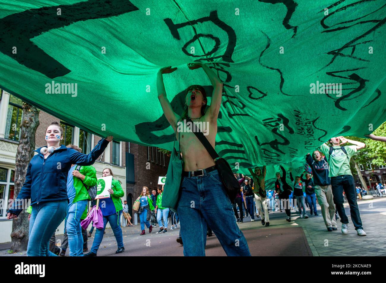 A man is dancing under a big green banner, during the Global Climate Strike organized in Utrecht, on September 24th, 2021. (Photo by Romy Arroyo Fernandez/NurPhoto) Stock Photo