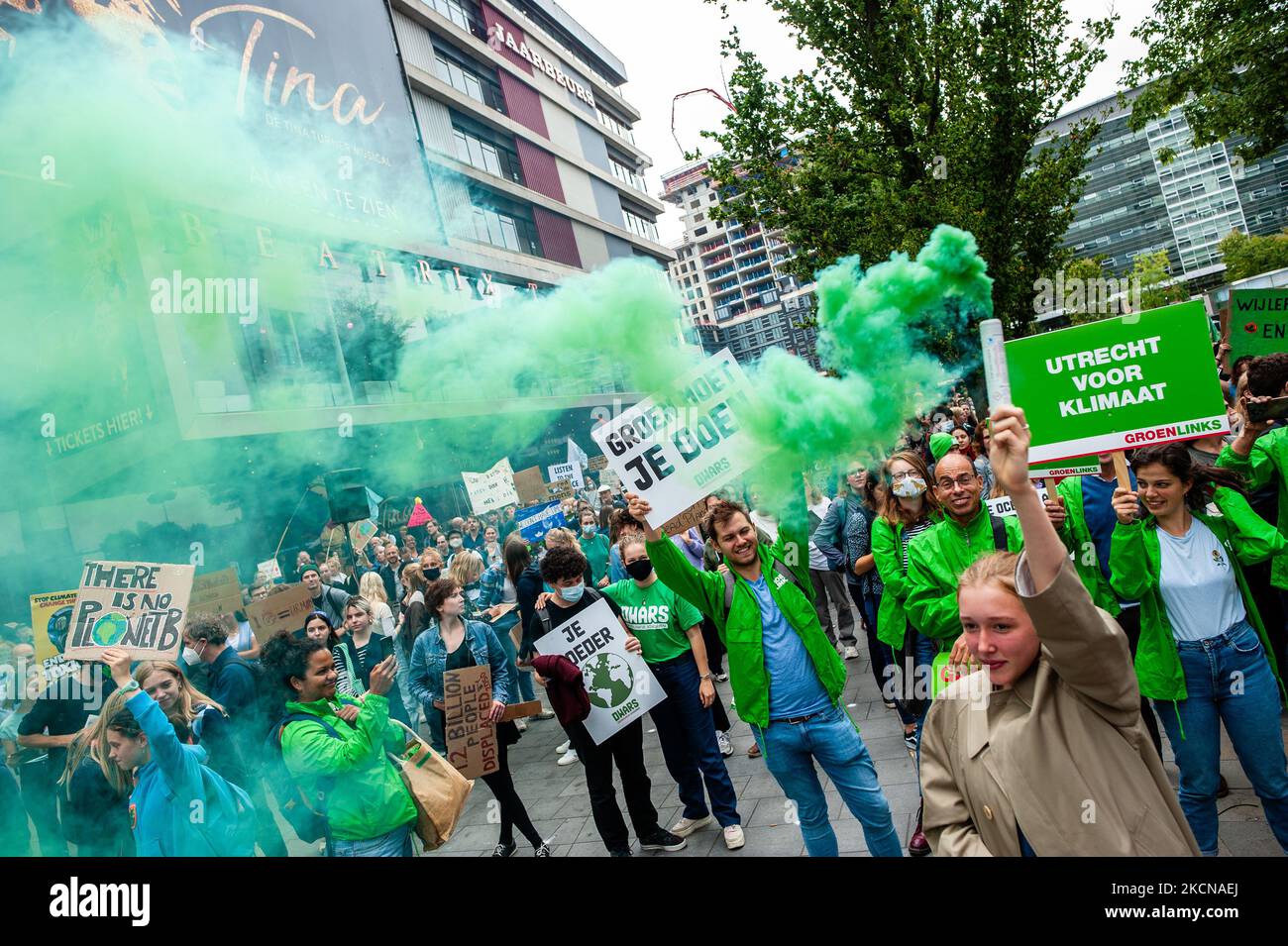 A woman is holding a green smoke bomb, during the Global Climate Strike organized in Utrecht, on September 24th, 2021. (Photo by Romy Arroyo Fernandez/NurPhoto) Stock Photo