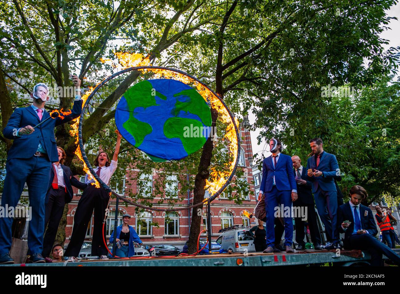 A group of activists is setting on fire a circle that represents the Earth, while they are dressing like politicians, during the Global Climate Strike organized in Utrecht, on September 24th, 2021. (Photo by Romy Arroyo Fernandez/NurPhoto) Stock Photo