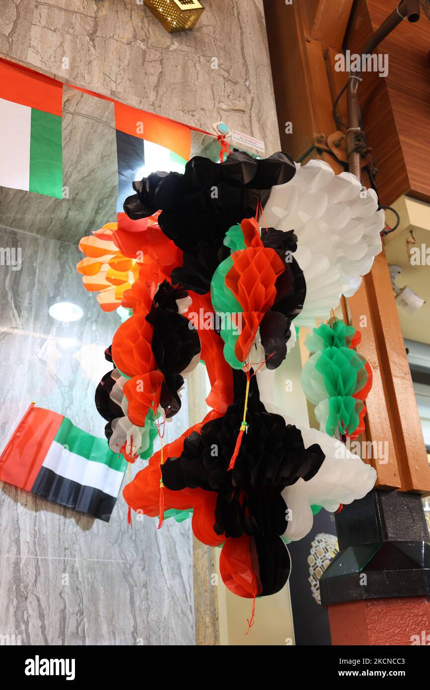Hanging decorations from many national flags of United Arab Emirates on street of Dubai. Natoinal Day UAE. Flags in rows waving in wind against blue sky. High quality photo Stock Photo