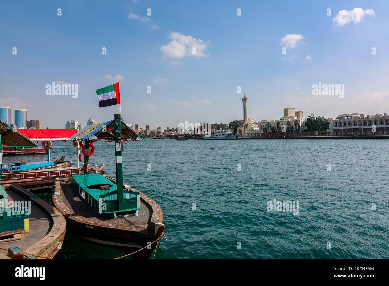 Big flag of United Arab Emirates flying high on city of Dubai in old town. Natoinal Day UAE. High quality photo Stock Photo