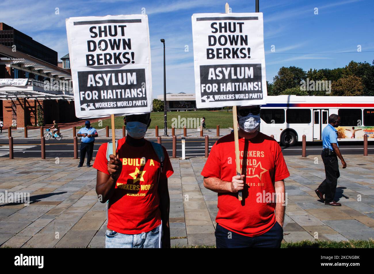Two socialist activists stand across the street from the Consitution Center carrying signs demanding asylum for Haitian refugees during a rally on Independence Mall to demand President Piden end ICE contracts with Berk county, in Philadelphia, PA, on September 25, 2021. (Photo by Cory Clark/NurPhoto) Stock Photo