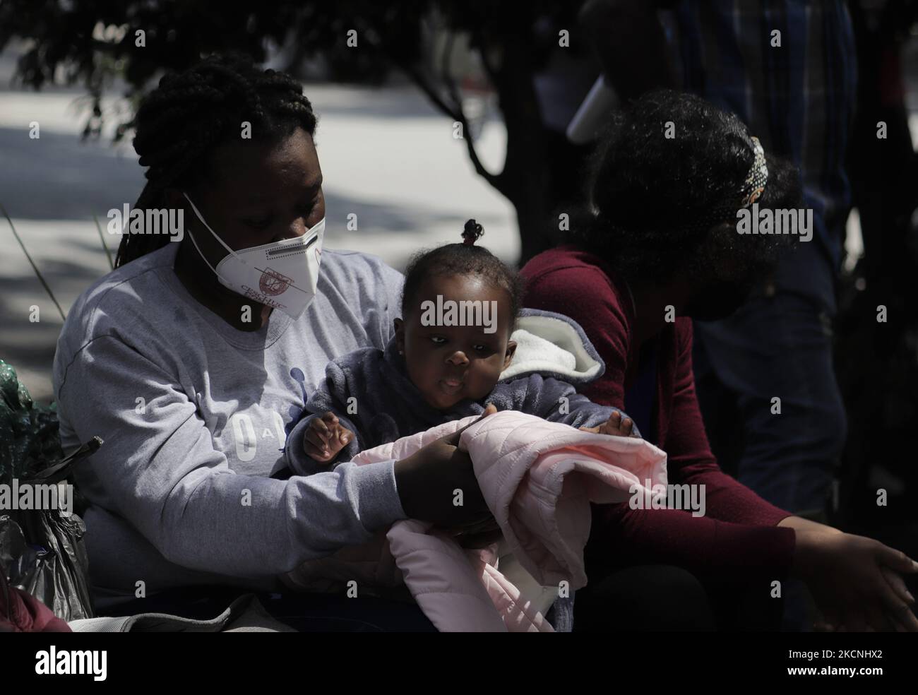 Haitian migrants sit on a bench outside the Mexican Commission for Refugee Support in Mexico City, where more migrants recently went to various refugee support offices to try to obtain a permit to stay longer in Mexico in the face of the difficulties their compatriots are having in entering the United States during the COVID-19 health emergency. (Photo by Gerardo Vieyra/NurPhoto) Stock Photo