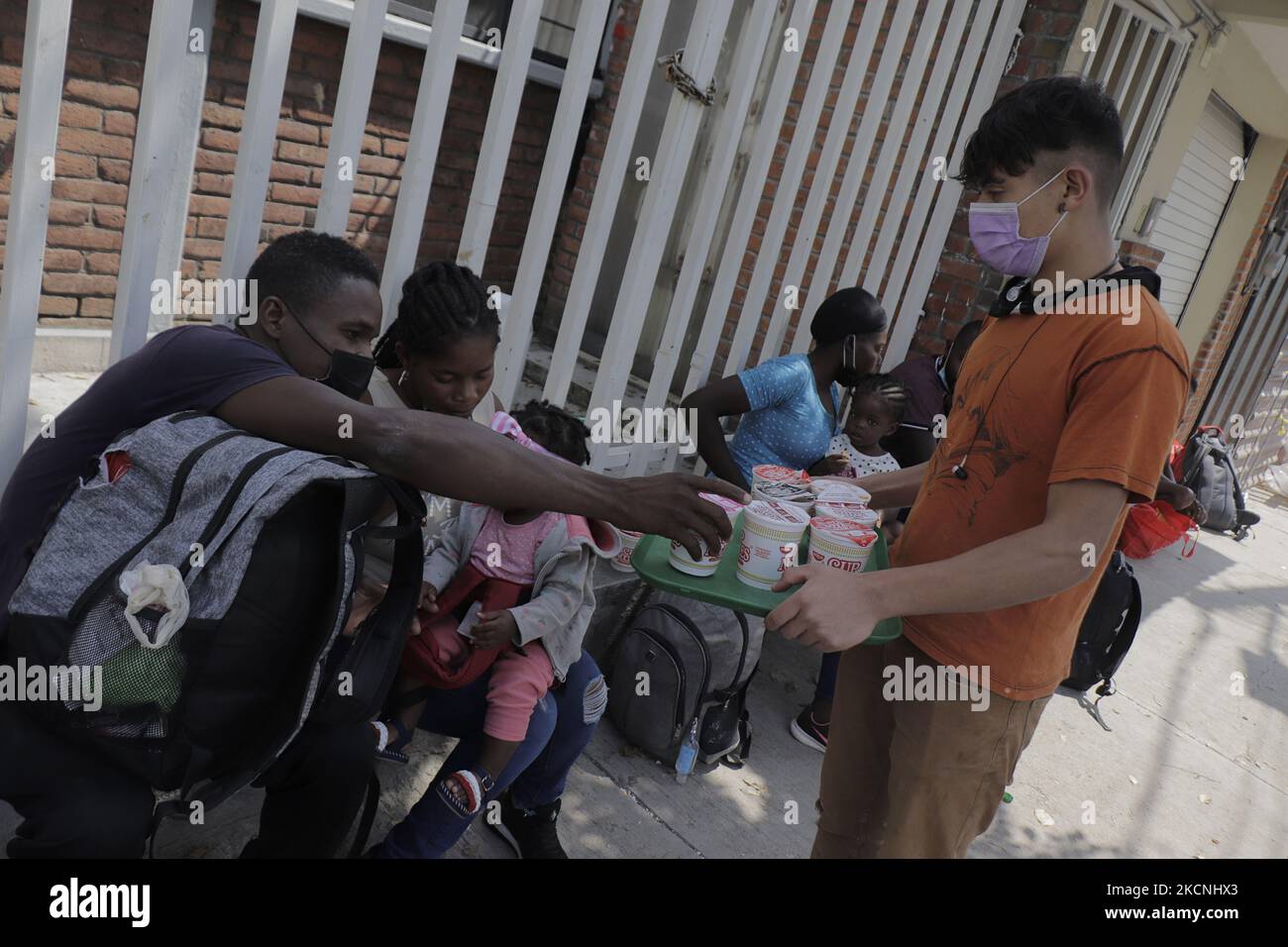 Workers at the Casa de Acogida Formación y Empoderamiento de la Mujer Migrante y Refugiada (CAFEMIN), located in Mexico City, Mexico, on September 27, 2021, offer instant soups to Haitian migrants who recently went to various refugee support offices to try to obtain a procedure that would allow them to stay longer in Mexico in view of the difficulties their compatriots are having in entering the United States during the COVID-19 health emergency. (Photo by Gerardo Vieyra/NurPhoto) Stock Photo