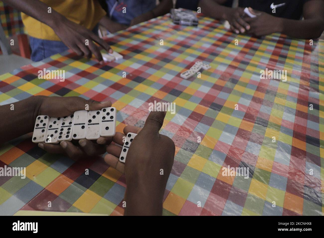 Haitian migrants play dominoes inside the Casa de Acogida Formación y Empoderamiento de la Mujer Migrante y Refugiada (CAFEMIN), located in Mexico City, Mexico, on September 27, 2021, which offers accommodation and food to Haitian migrants who recently went to various refugee support offices to try to obtain a permit to stay longer in Mexico in view of the difficulties their compatriots are having in entering the United States during the COVID-19 health emergency. (Photo by Gerardo Vieyra/NurPhoto) Stock Photo