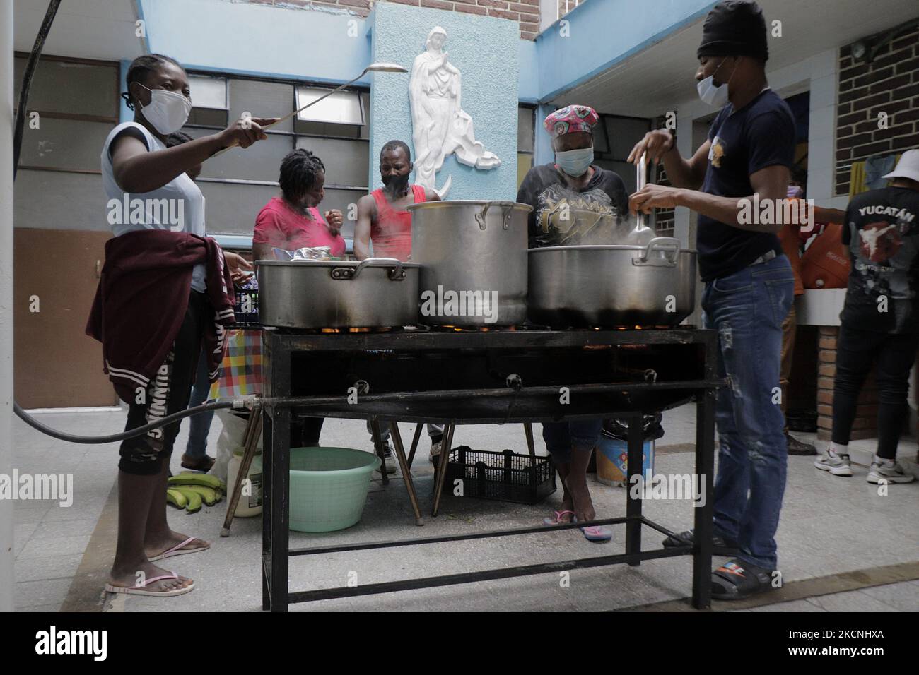 Haitian migrants cook inside the Casa de Acogida Formación y Empoderamiento de la Mujer Migrante y Refugiada (CAFEMIN), located in Mexico City, Mexico, on September 27, 2021, which offers lodging and food to migrants who recently went to various refugee support offices to try to complete a procedure that would allow them to stay longer in Mexico given the difficulties their compatriots are having in entering the United States during the COVID-19 health emergency. (Photo by Gerardo Vieyra/NurPhoto) Stock Photo