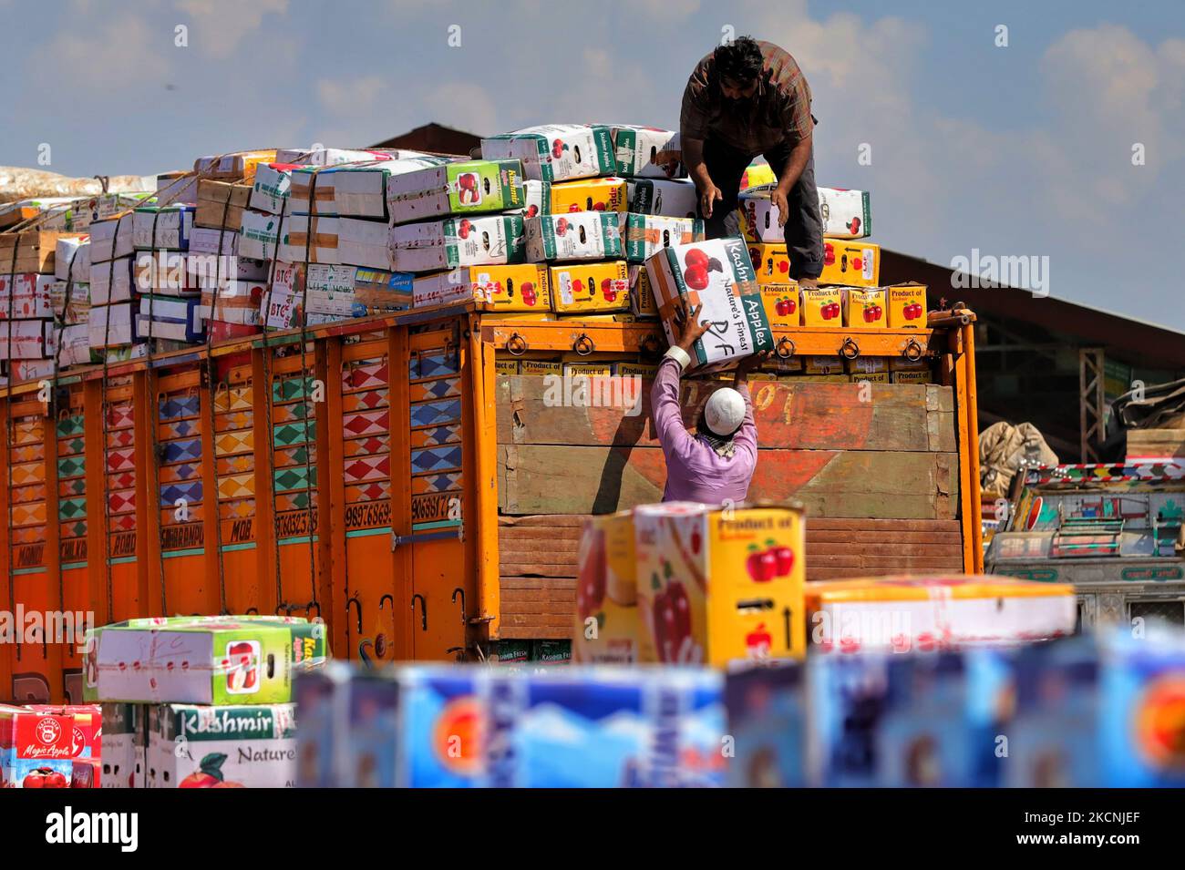 Kashmiri labourers carry boxes of Apples to be loaded onto trucks at a wholesale fruit market in Sopore, District baramulla, Jammu and Kashmir, India, some 54kms north of Srinagar, on 28 September 2021. Jammu & Kashmir boasts of around 80% share of total apple produced in the country.Â Apple cultivation and its value chain is one of the main stays of rural economy with revenue of around Rs. 1500 crores.Â The apple production is predominantly confined to districts of Srinagar, Ganderbal, Budgam, Baramulla, Kupwara, Anantnag and Shopian in Kashmir province. (Photo by Nasir Kachroo/NurPhoto) Stock Photo