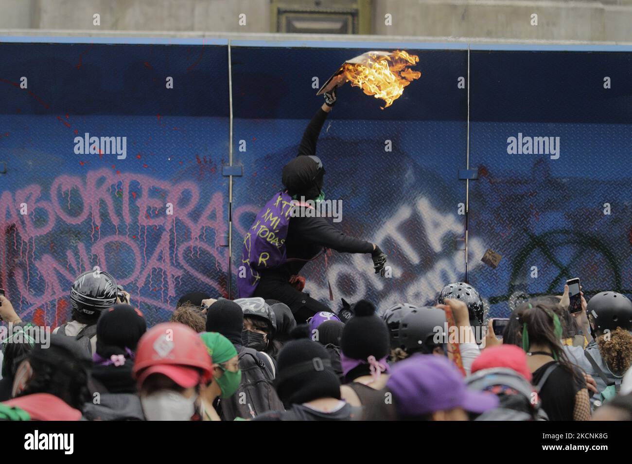 A woman from the feminist Black Bloc sets fire in front of fences placed under the Angel of Independence in Mexico City, on the occasion of the Global Day of Action in favour of legal, free and safe abortion in Mexico and Latin America. During the march, there were clashes between demonstrators and police along the route. (Photo by Gerardo Vieyra/NurPhoto) Stock Photo