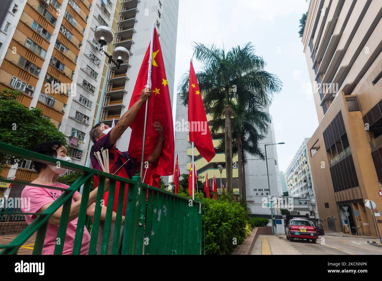 Two members of the Democratic Alliance for the Betterment and Progress of Hong Kong (DAB) hang Chinese flags in Ping Shek Estate. (Photo by Marc Fernandes/NurPhoto) Stock Photo