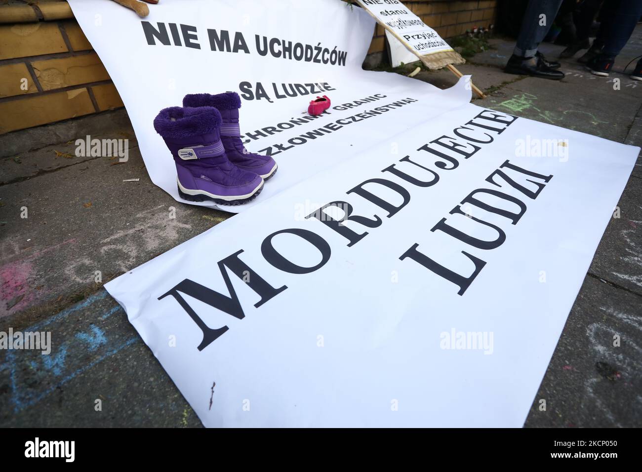 A sign reading 'You murder people' is seen in Warsaw, Poland on 01 October, 2021. About a hundred people rallied in front of the headquarters of the Polish Border Guards to protest the practice of push-backs. Thousands of migrants, mainly from Iraq have been forced over the border from Belarus into Poland and the Baltics since the start of the summer. Poland has responded by pushing-back the migraints into Belarus, a practice that is in clear defiance of interniontal regulations ane EU law. (Photo by STR/NurPhoto) Stock Photo