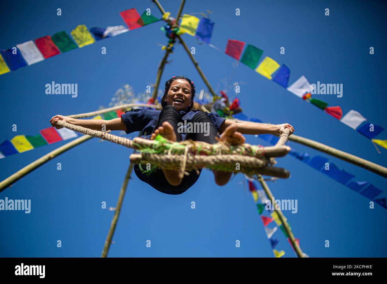 A Nepalese kid rides a traditional swing set up as part Dashain