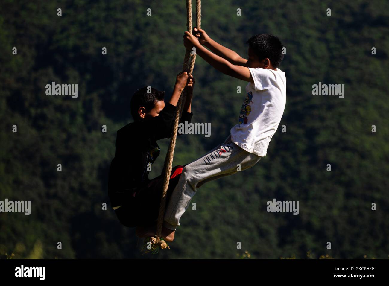 Nepalese kids ride a traditional swing set up as part Dashain festival