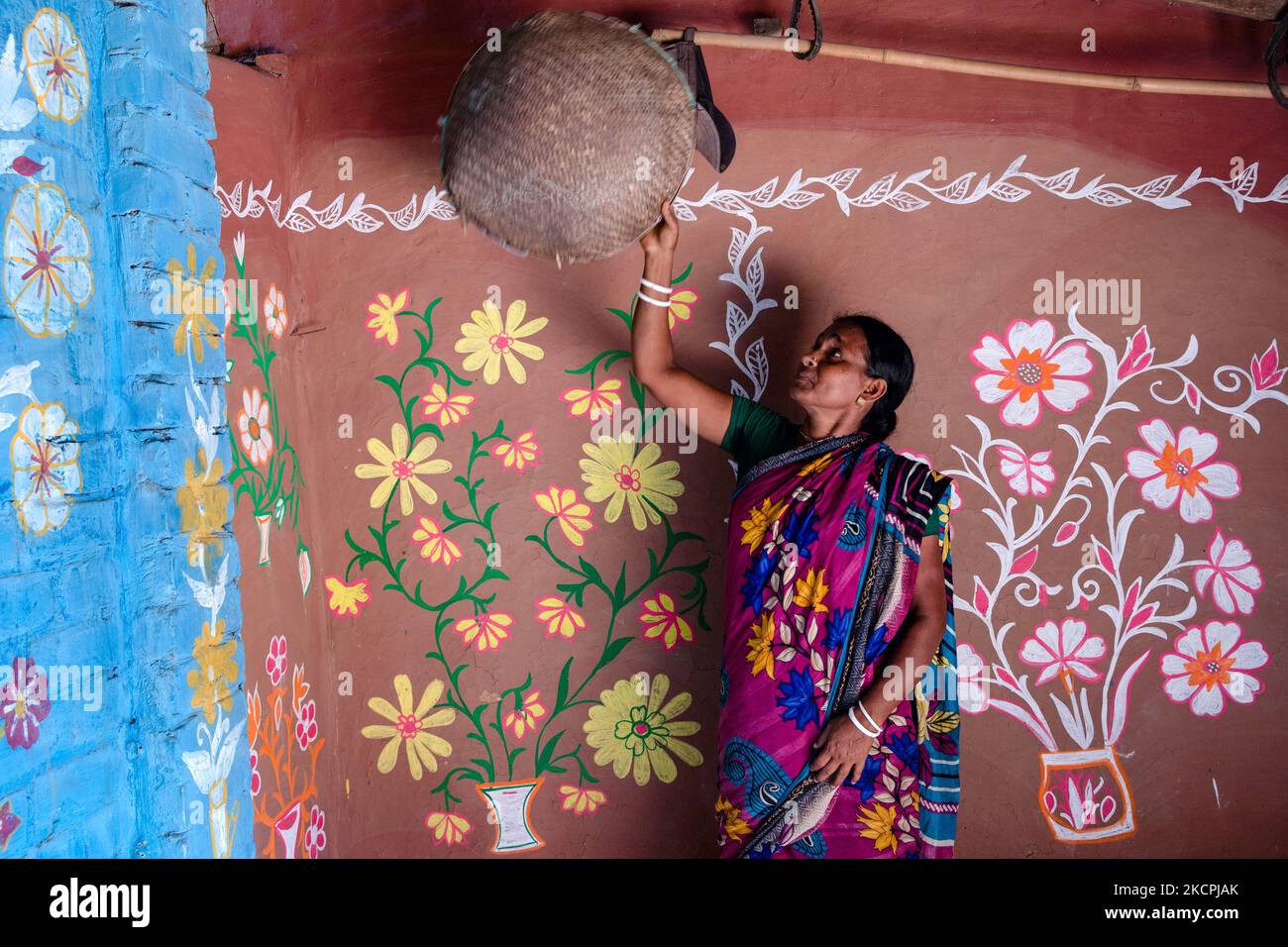A woman works inside her colorful painted house in alpona village in chapainawabganj, Bangladesh (Photo by Mushfiqul Alam/NurPhoto) Stock Photo