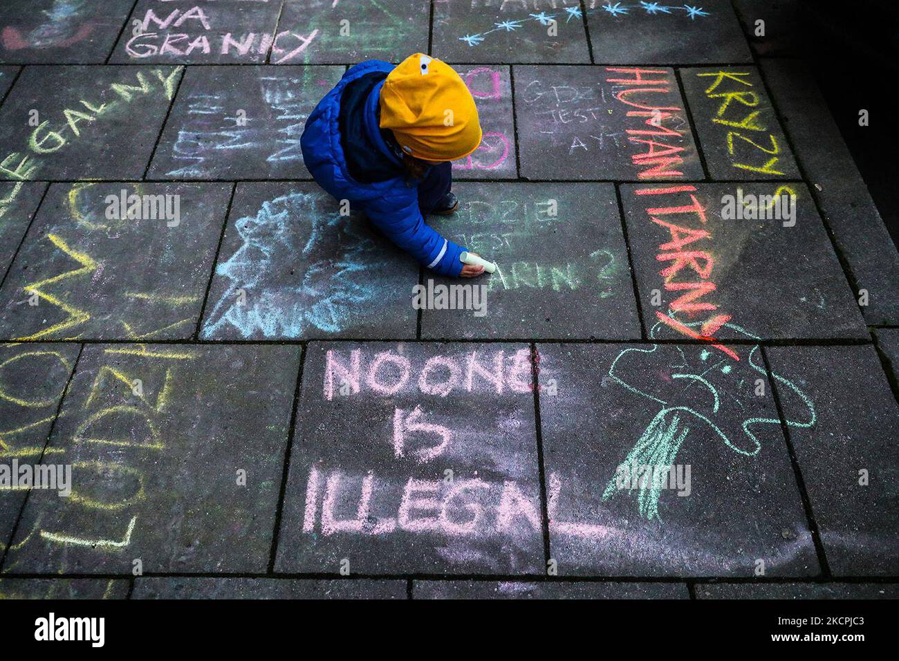 Chalk drawings and slogans were put on the pavement in front of Law and Justice (PiS) ruling party's office during a protest against the government's treatment of refugees, on the day when Syrian migrant was found dead on Polish-Belarusian border. Krakow, Poland on October 14, 2021. Few days before, a group of mothers with children, who are the representatives of 'Family Without Borders' initiative, made chalk drawings on the sidewalks in front of the headquarters of the Law and Justice party on Retoryka Street in Krakow. The police that arrived at the place, confiscated chalk and drawings wer Stock Photo