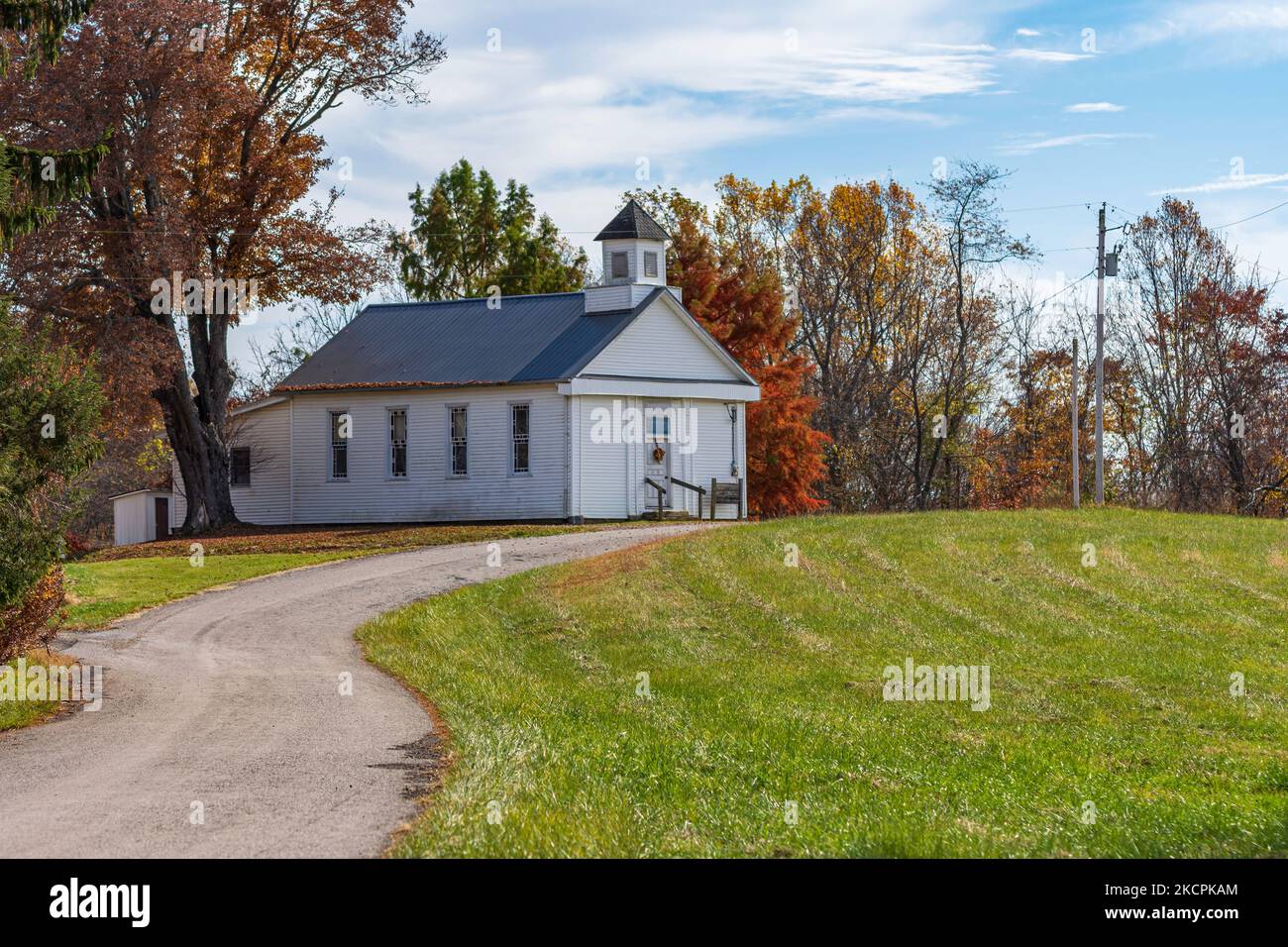 An old white wooden clapboard country church, typical of those found in rural Appalachia on winding road in autumn. Stock Photo
