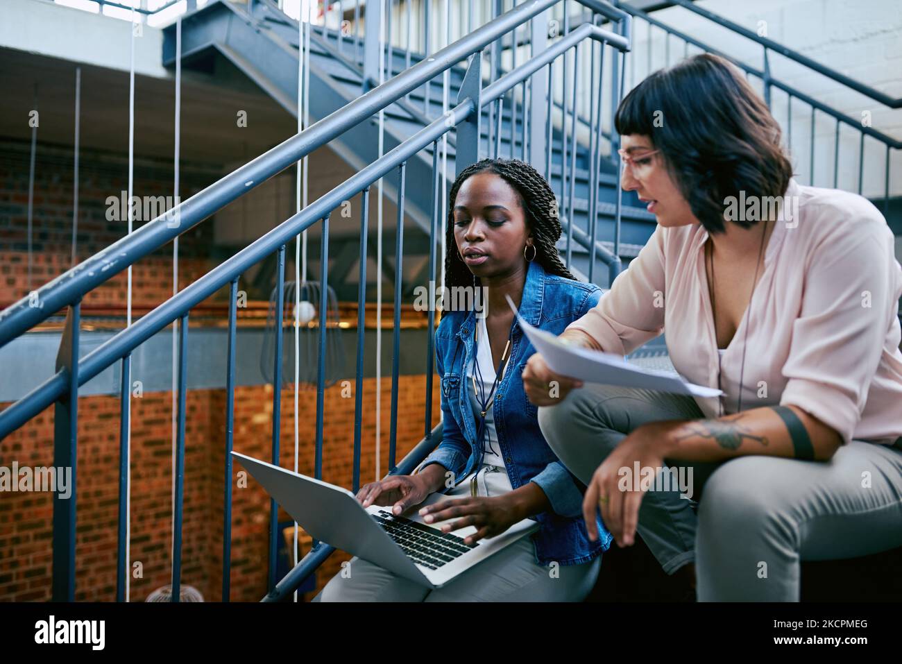 Submitting their project online. two colleagues collaborating in a modern office. Stock Photo