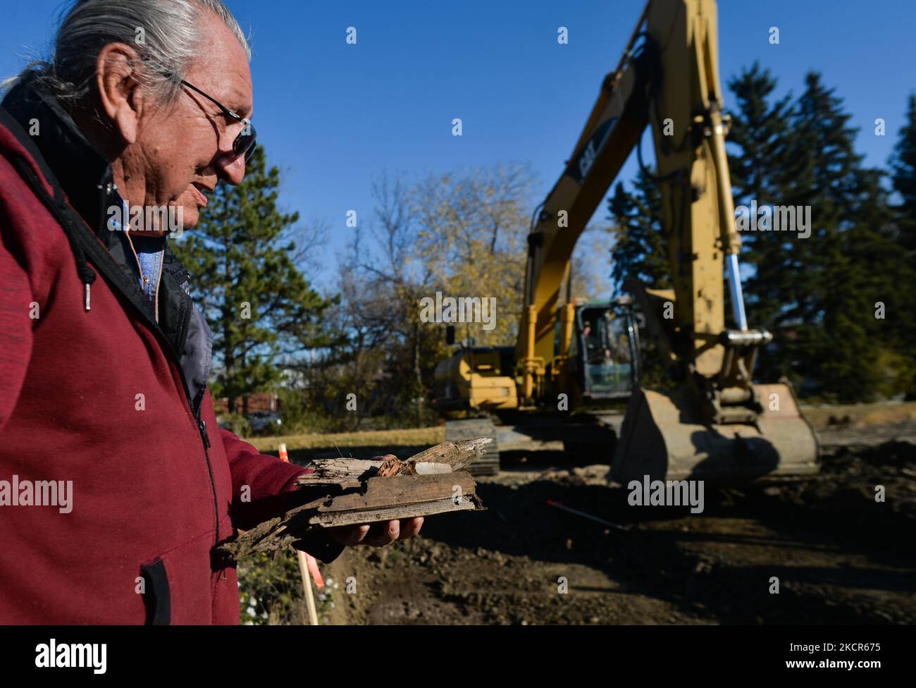 Elder Fernie Marty from the Papaschase First Nation with found pieces of wood, as he monitors excavations on the grounds of the former Charles Camsell Hospital, in Edmonton. Second phase of excavation work began today at the site of the former Charles Camsell Hospital, the Edmonton facility that for decades was used to treat Indigenous people with tuberculosis. First Nation members have been calling for construction to stop at the grounds where many believe patients may have been buried. The search is being funded by the property's developer. On Thursday, 21 October 2021, in Inglewood, Edmonto Stock Photo