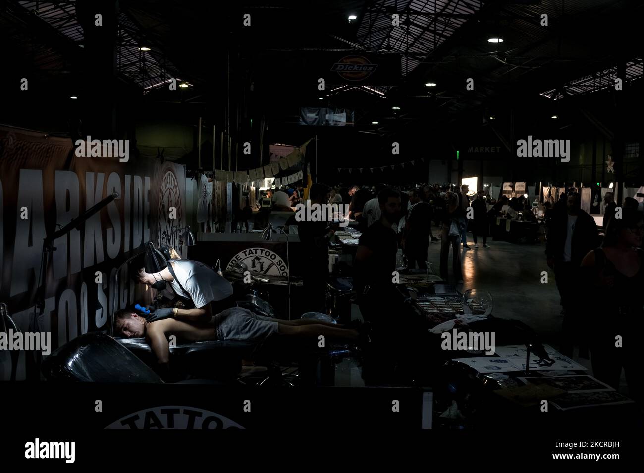 Tattoo artists seen working on a customer during the 5th Athens Tattoo