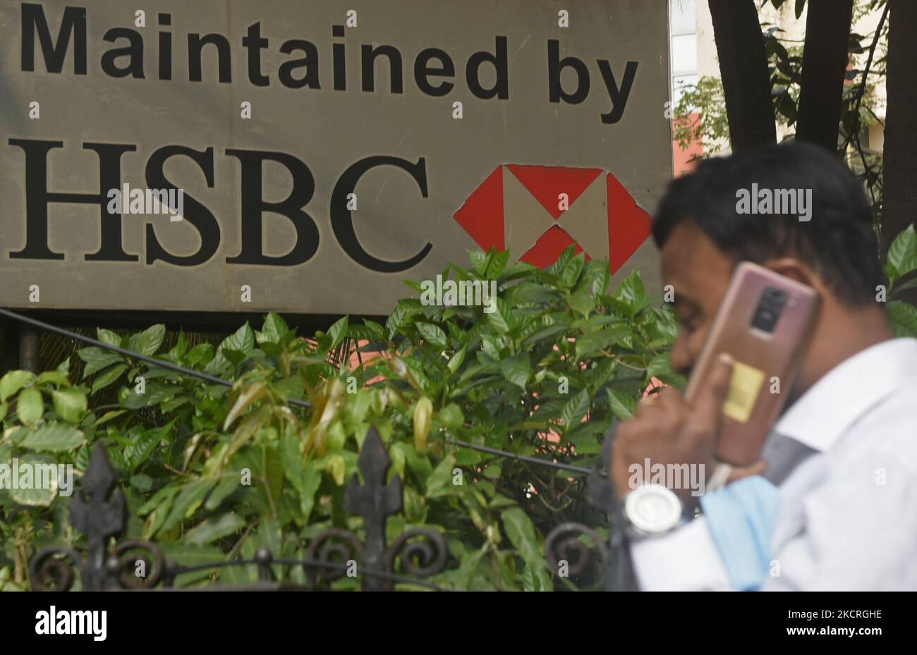A man talks on phone passes by HSBC logo in Kolkata, India, 25 October, 2021. HSBC’s profits rose 74% in the third quarter as improving economic conditions allowed the bank to release hundreds of millions of pounds originally set aside for a potential jump in loan defaults during the pandemic according to an Indian media report. (Photo by Indranil Aditya/NurPhoto) Stock Photo