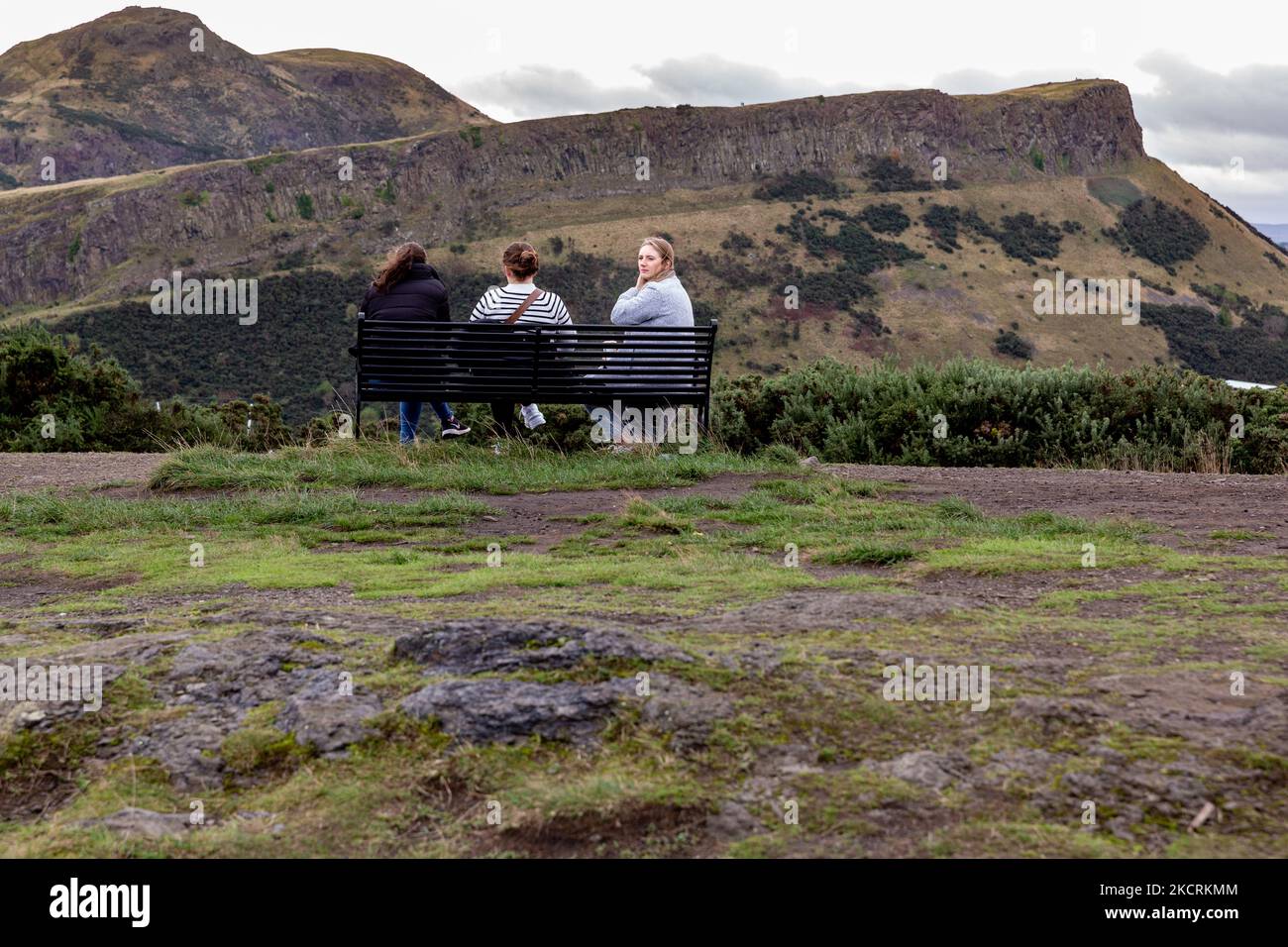 Tourists sit on a banch in front of Hollyrood Park as autumn weather with showers and strong wind struck Edinburgh, the capital of Scotland on October 27, 2021. Despite poor weather and the aftermaths of Covid-19 pandemic Edinburgh is full of tourists. (Photo by Dominika Zarzycka/NurPhoto) Stock Photo