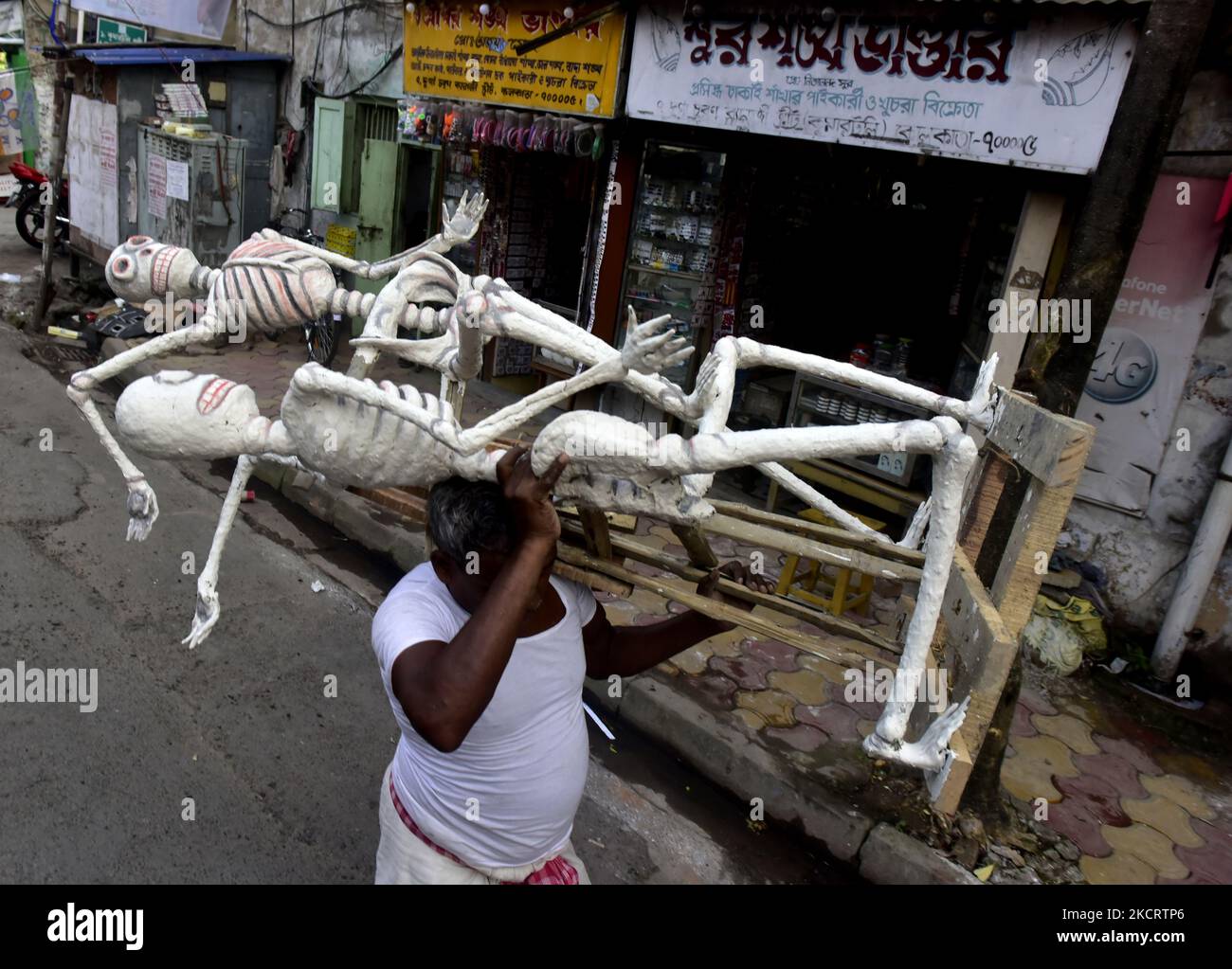 A worker carries skeleton structure for pandal decoration of the upcoming Kali puja festival in Kolkata, India, 30 October, 2021. Goddess Kali is being worshipped as a saviors from all evil forces, demons and a source of Power, Happiness as per Hindu Mythology. (Photo by Indranil Aditya/NurPhoto) Stock Photo