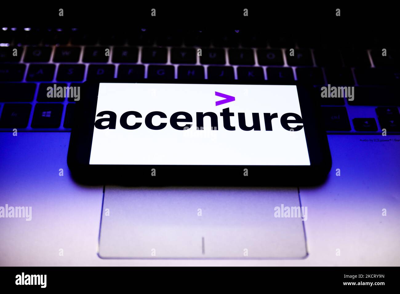 Accenture logo displayed on a phone screen and a laptop keyboard are seen in this illustration photo taken in Krakow, Poland on October 31, 2021. (Photo by Jakub Porzycki/NurPhoto) Stock Photo