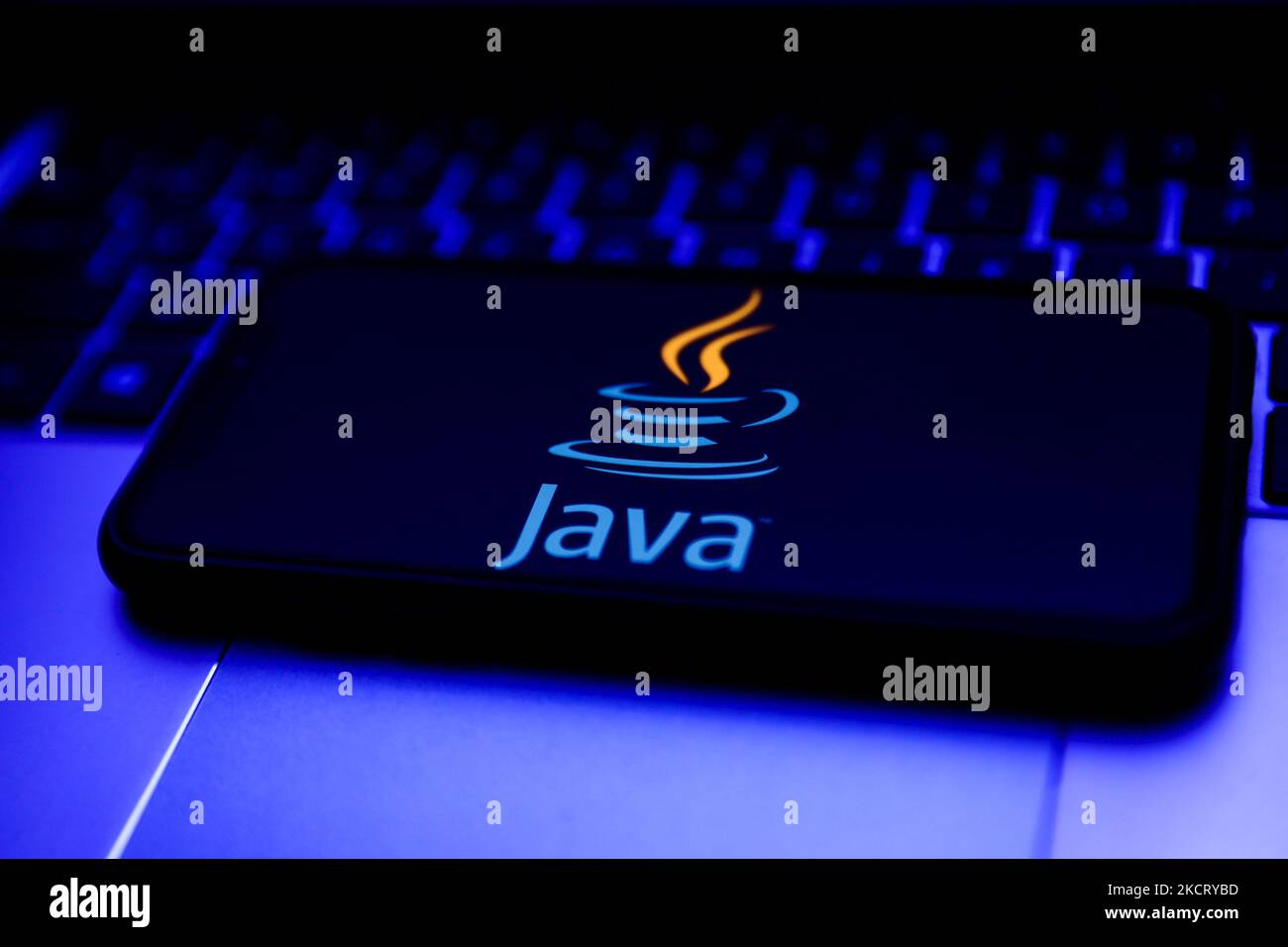 Java logo displayed on a phone screen and a laptop keyboard are seen in this illustration photo taken in Krakow, Poland on October 31, 2021. (Photo by Jakub Porzycki/NurPhoto) Stock Photo
