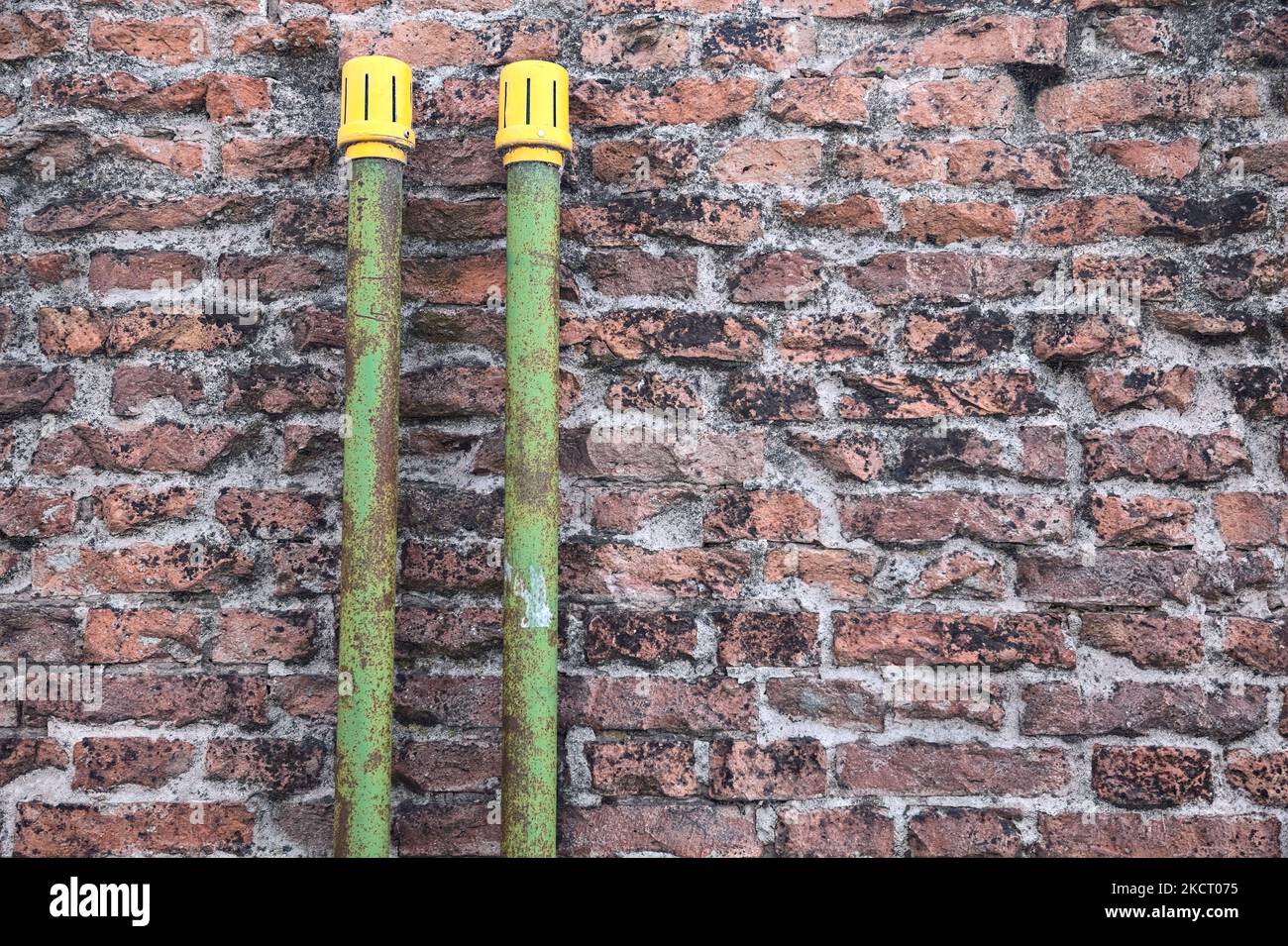 Green  pipes on a brick wall Stock Photo
