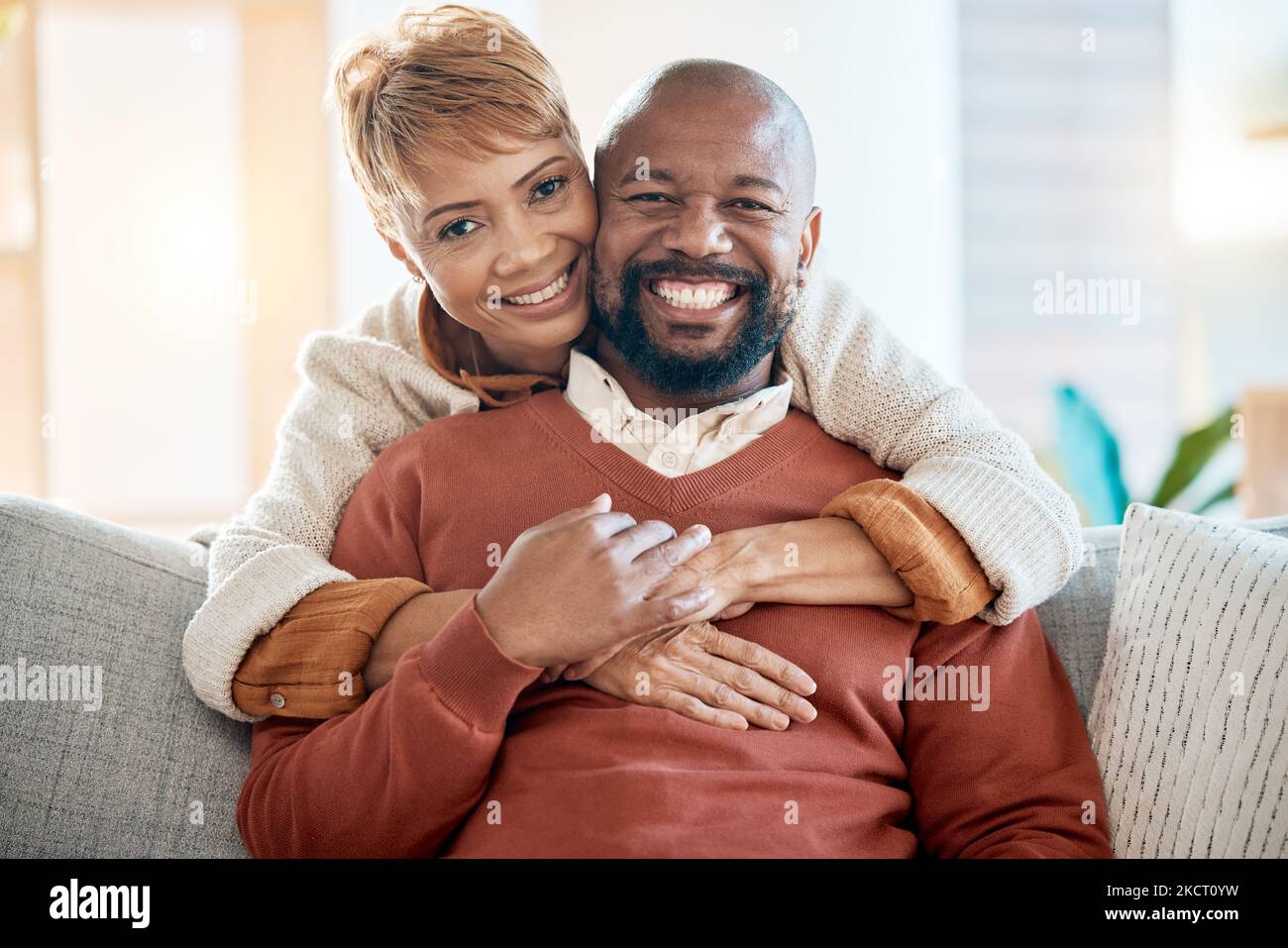Happy, love and portrait of black couple on sofa for relax, retirement or support together. Smile, hug or marriage with old man and woman in living Stock Photo