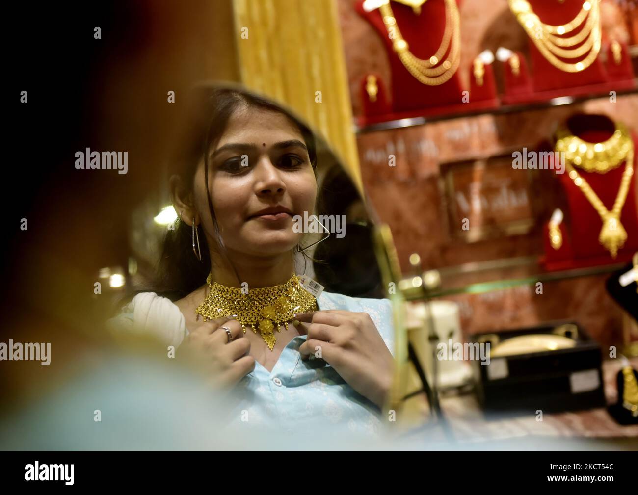 An Indian woman buys gold ornaments inside a jewellery showroom during