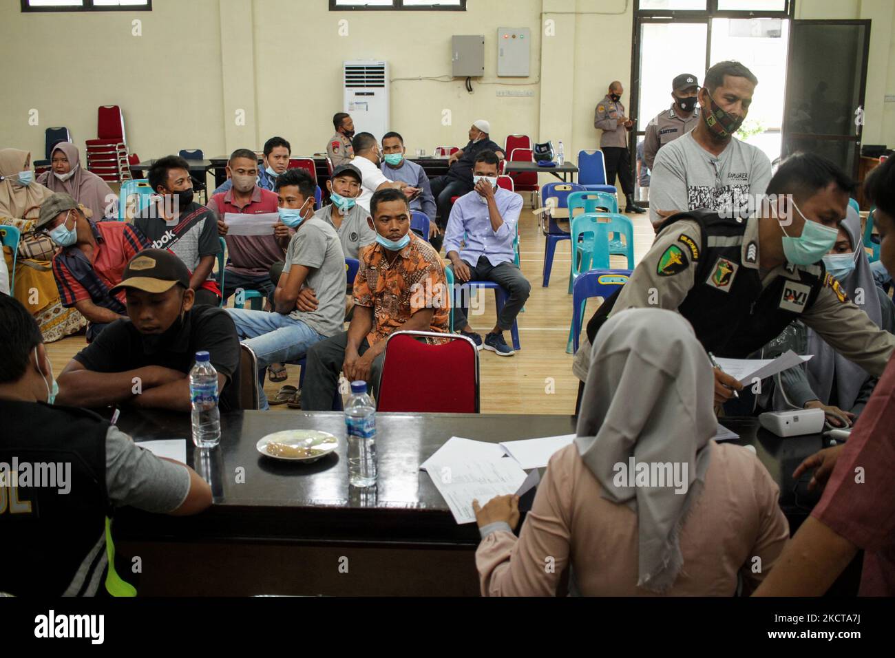 People are seen waiting for their turn to get the Moderna vaccine