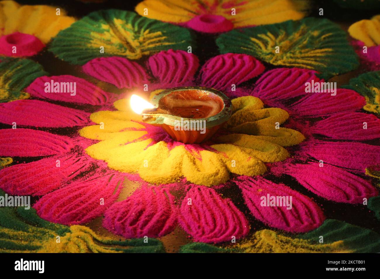 Diya (small clay lamp) by a colourful rangloli design that was created using coloured powder during the festival of Diwali at a Hindu temple in Toronto, Ontario, Canada, on November 04, 2021. Rangoli is a traditional design drawn on the ground with colored powder, often in front of homes or temples. (Photo by Creative Touch Imaging Ltd./NurPhoto) Stock Photo