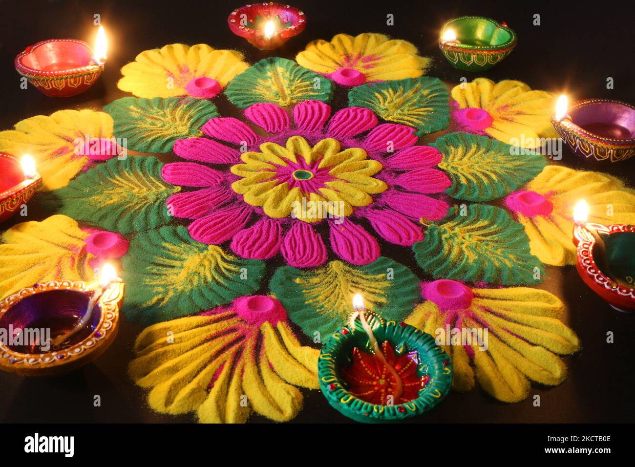 Diyas (small clay lamps) by a colourful rangloli design that was created using coloured powder during the festival of Diwali at a Hindu temple in Toronto, Ontario, Canada, on November 04, 2021. Rangoli is a traditional design drawn on the ground with colored powder, often in front of homes or temples. (Photo by Creative Touch Imaging Ltd./NurPhoto) Stock Photo