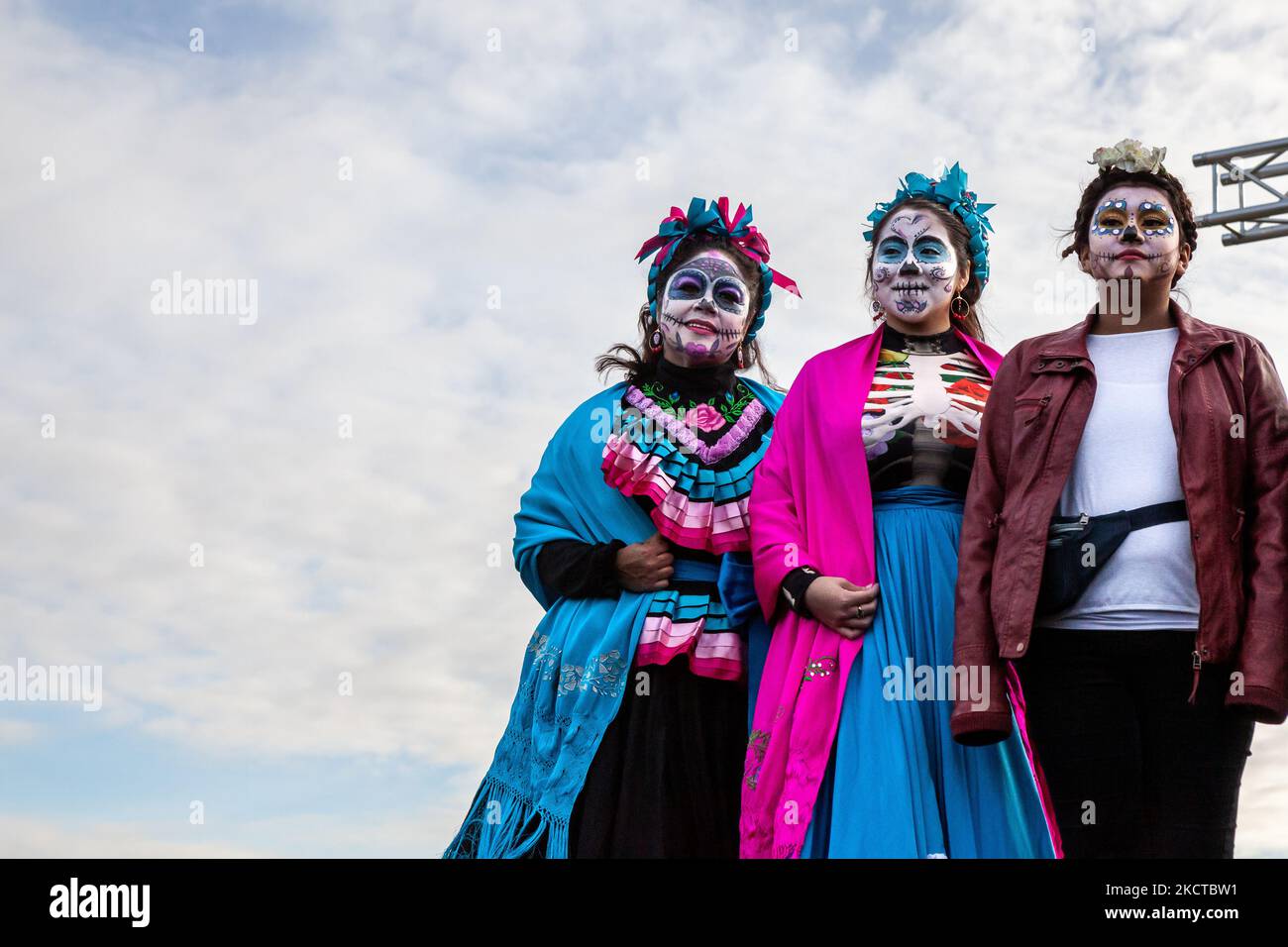 3 Catrinas pose on stage during the Día de los Muertos benefit and festival on the National Mall. In addition to celebrating the holiday, the festival has two additional purposes: federal recognition of Día de los Muertos as an important cultural day and fundraising for organizations that reunite families separated at the border by US Immigration and Customs Enforcement (ICE). (Photo by Allison Bailey/NurPhoto) Stock Photo