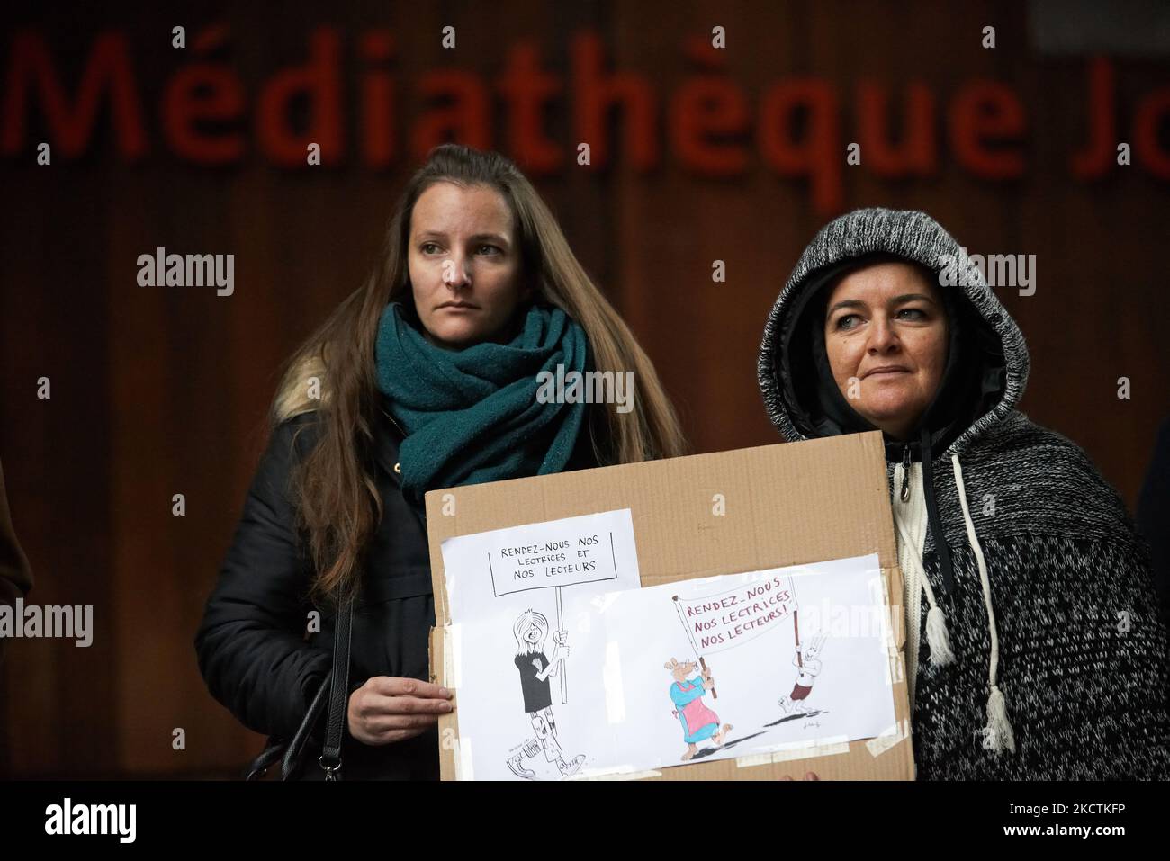 Two librarians in front of the Jose Cabanis library hold drawings ...