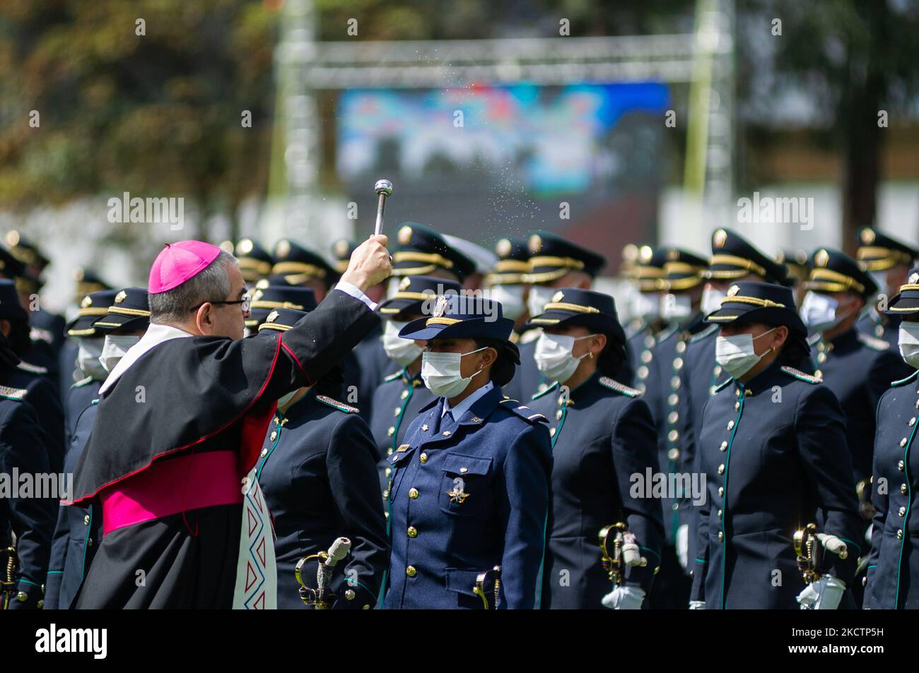 A priest sprays holy water to newly promoted Police officers participate in their promotion ceremony during an event were Colombia's president Ivan Duque Marquez and Colombia's Minister of Defense Diego Molano in conmmemoration of the 130 anniversary of Colombia's National Police and the promotion to officers to more than a 100 police members, in Bogota, Colombia on November 11, 2021. (Photo by Sebastian Barros/NurPhoto) Stock Photo