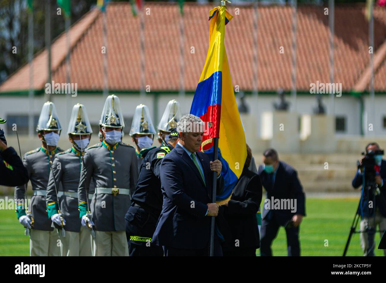 Colombia's president Ivan Duque Marquez carries a Colombian flag and hands it to a officer during an event were Colombia's president Ivan Duque Marquez and Colombia's Minister of Defense Diego Molano in conmmemoration of the 130 anniversary of Colombia's National Police and the promotion to officers to more than a 100 police members, in Bogota, Colombia on November 11, 2021. (Photo by Sebastian Barros/NurPhoto) Stock Photo