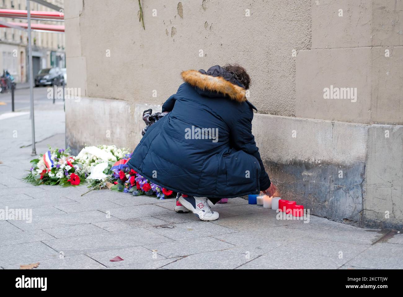 A man lights candles near the Petit Cambodge and Petit Carillon restaurants, which were targeted by terrorists, in Paris, France, on November 13, 2021. (Photo by Vincent Koebel/NurPhoto) Stock Photo