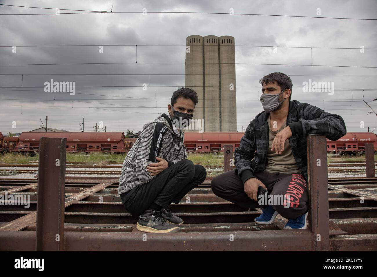 Young men from Afghanistan as seen on the old carriages waiting for the train. Refugees and migrants are seen at the railway junction and the old abandoned train carriages living and sleeping temporarily in Dialogi near Thessaloniki. Asylum seekers mostly from Afghanistan are waiting for cargo trains to jump on and travel towards Idomeni that leads to Northern Macedonia and Serbia, following the Balkan Route to Europe. Most of them walked from Turkey towards Greece or some used smugglers with cars. Thessaloniki Greece on November 6, 2021 (Photo by Nicolas Economou/NurPhoto) Stock Photo